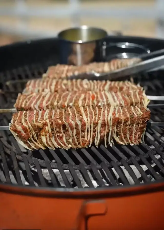 Brushing sizzling Beef Tortilla Skewers with garlic butter while grilling