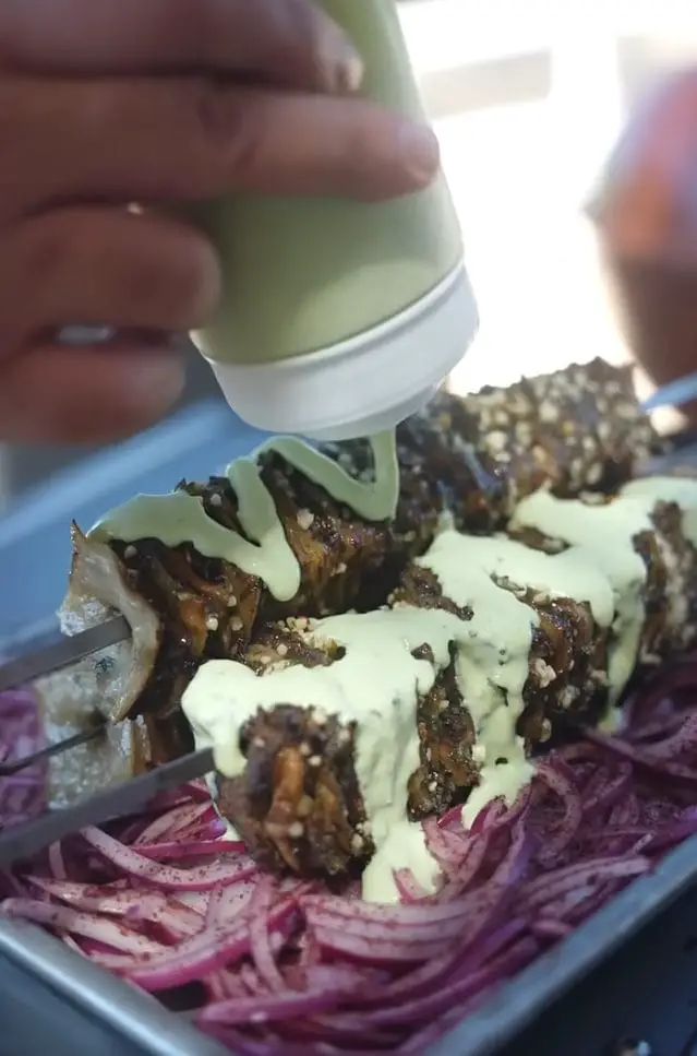 Plated crispy Viral Beef Tortilla Skewers with cilantro jalapeño crema dip