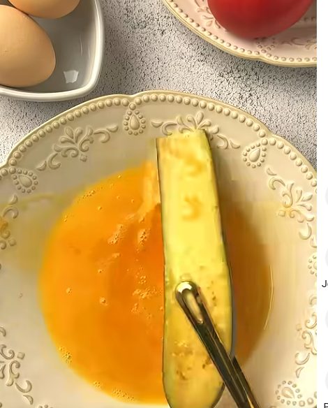Dipping eggplant slices in beaten egg before frying for Crispy Eggplant Salad