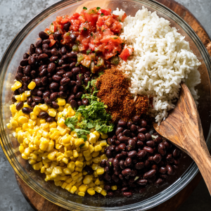 Mixing rice, beans, corn, salsa, and taco seasoning for taco casserole