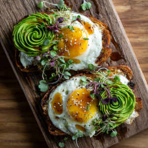 Cloud toast with fluffy baked eggs, avocado rose, honey drizzle, and microgreens