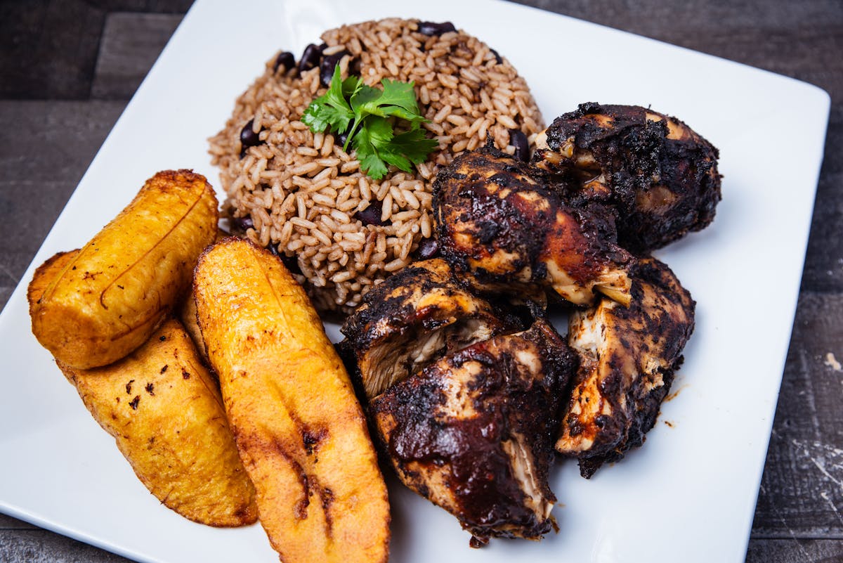 Jamaican jerk chicken served with rice and fried plantains